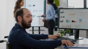 Invalid worker with disabilities working at computer